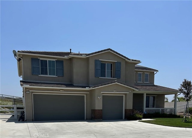 17426 Fairbreeze Ct, Riverside, CA 92504 - view of front of home with a garage, stucco siding, concrete driveway, and a porch