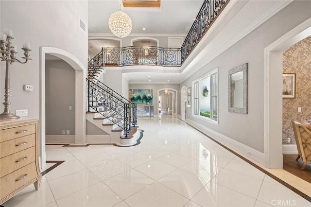 2108 S 2nd Ave, Arcadia, CA 91006 - entrance foyer featuring arched walkways, a towering ceiling, inlaid floor details, stairs, and crown molding