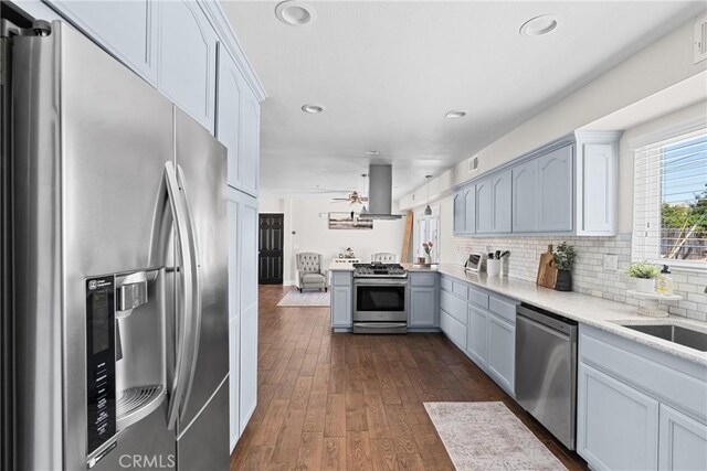 4198 Woodland St, Santa Maria, CA 93455 - kitchen with stainless steel appliances, island exhaust hood, light countertops, ceiling fan, and dark wood-style floors