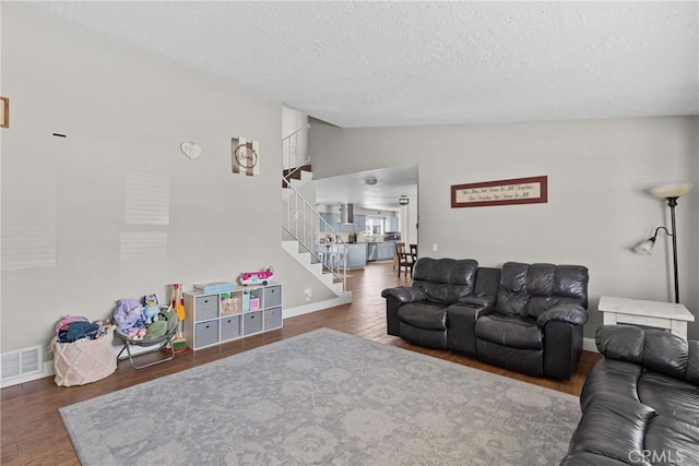 4198 Woodland St, Santa Maria, CA 93455 - living area featuring vaulted ceiling, stairs, a textured ceiling, wood finished floors, and baseboards