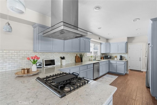 4198 Woodland St, Santa Maria, CA 93455 - kitchen with island range hood, appliances with stainless steel finishes, decorative backsplash, a sink, and light stone counters