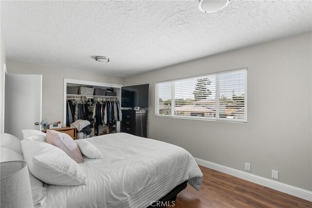 4198 Woodland St, Santa Maria, CA 93455 - bedroom with wood finished floors, baseboards, a closet, and a textured ceiling