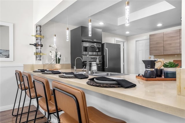 18165 Sharon Cir, Yorba Linda, CA 92886 - kitchen with a breakfast bar area, freestanding refrigerator, recessed lighting, wood finished floors, and light countertops