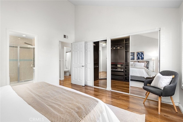 18165 Sharon Cir, Yorba Linda, CA 92886 - bedroom featuring multiple closets, wood finished floors, a towering ceiling, and ensuite bathroom