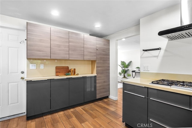 18165 Sharon Cir, Yorba Linda, CA 92886 - kitchen featuring wall chimney range hood, gas cooktop, wood finished floors, light countertops, and modern cabinets