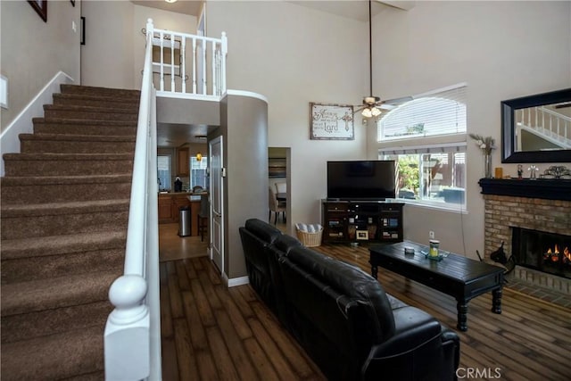 11103 Muirfield Dr, Rancho Cucamonga, CA 91730 - living area featuring wood finished floors, stairs, ceiling fan, a high ceiling, and a fireplace