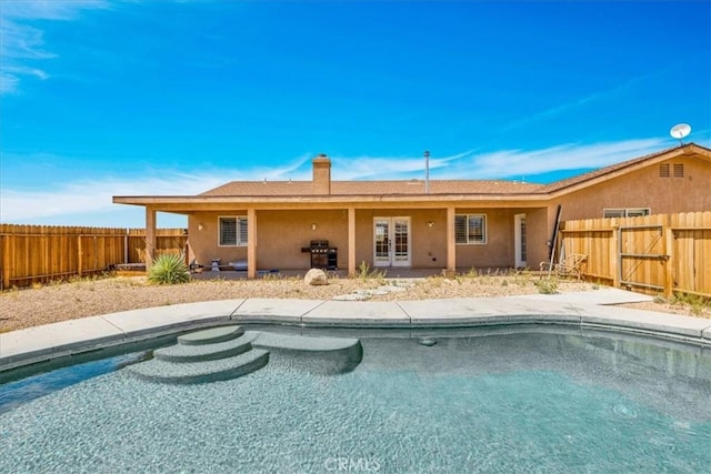 63357 Uranium Rd, Joshua Tree, CA 92252 - back of property with a fenced backyard, stucco siding, and french doors