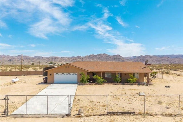 63357 Uranium Rd, Joshua Tree, CA 92252 - ranch-style home featuring an attached garage, a mountain view, a fenced front yard, concrete driveway, and a gate