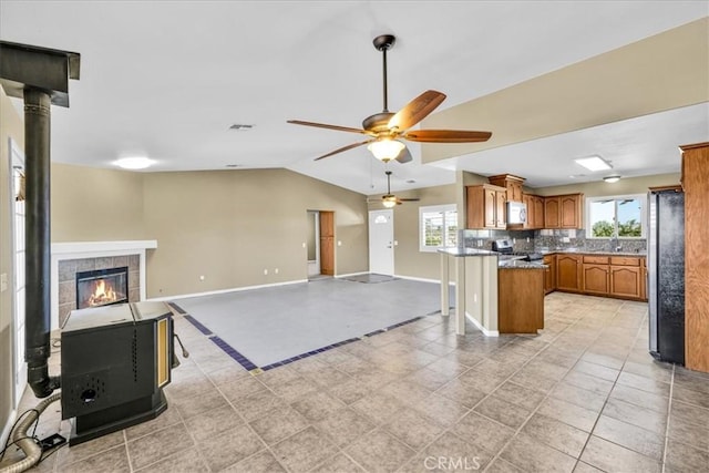 63357 Uranium Rd, Joshua Tree, CA 92252 - kitchen featuring stainless steel appliances, brown cabinetry, open floor plan, a ceiling fan, and decorative backsplash