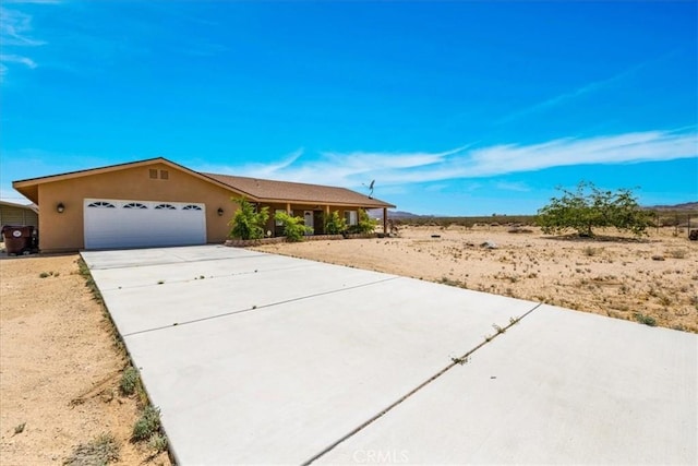 63357 Uranium Rd, Joshua Tree, CA 92252 - ranch-style home featuring a garage, concrete driveway, and stucco siding