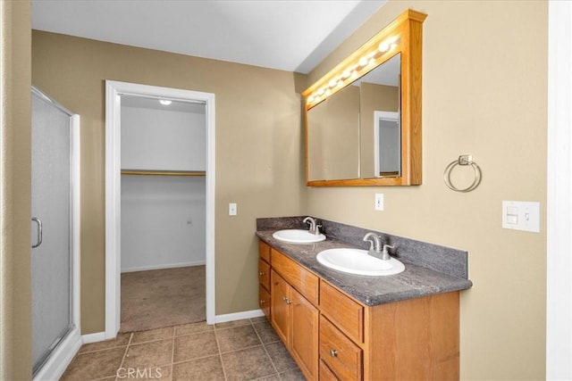 63357 Uranium Rd, Joshua Tree, CA 92252 - bathroom with double vanity, a stall shower, tile patterned flooring, baseboards, and a spacious closet