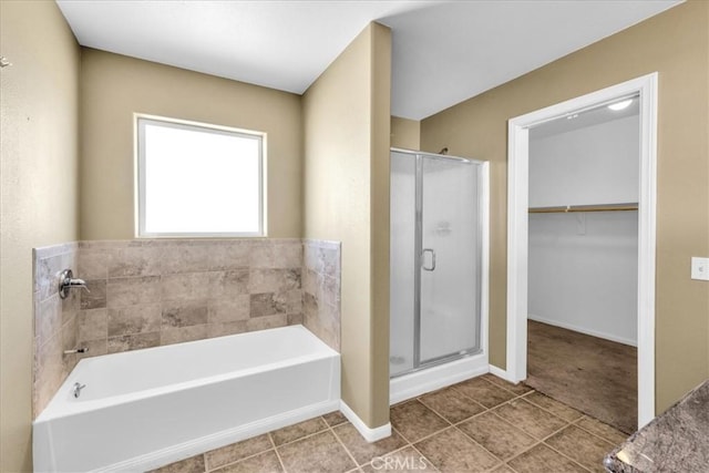 63357 Uranium Rd, Joshua Tree, CA 92252 - bathroom featuring a shower stall, a garden tub, a spacious closet, tile patterned flooring, and baseboards