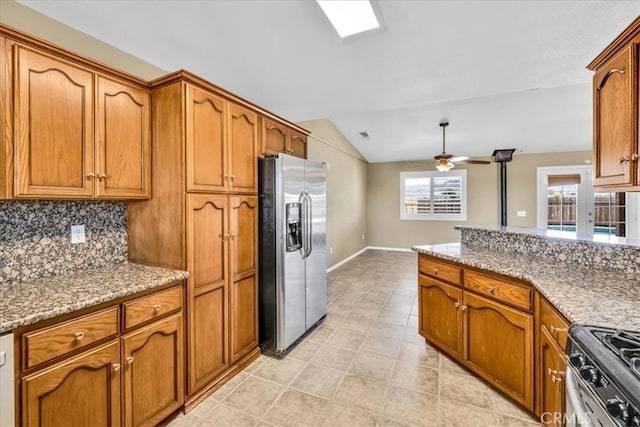 63357 Uranium Rd, Joshua Tree, CA 92252 - kitchen featuring stainless steel appliances, brown cabinetry, a ceiling fan, vaulted ceiling, and baseboards