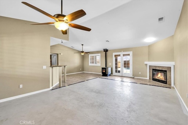 63357 Uranium Rd, Joshua Tree, CA 92252 - unfurnished living room featuring a wood stove, concrete floors, baseboards, lofted ceiling, and ceiling fan
