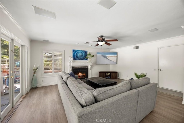 20660 Calle Feliz, Yorba Linda, CA 92886 - living room with light wood-type flooring, a glass covered fireplace, ceiling fan, crown molding, and french doors