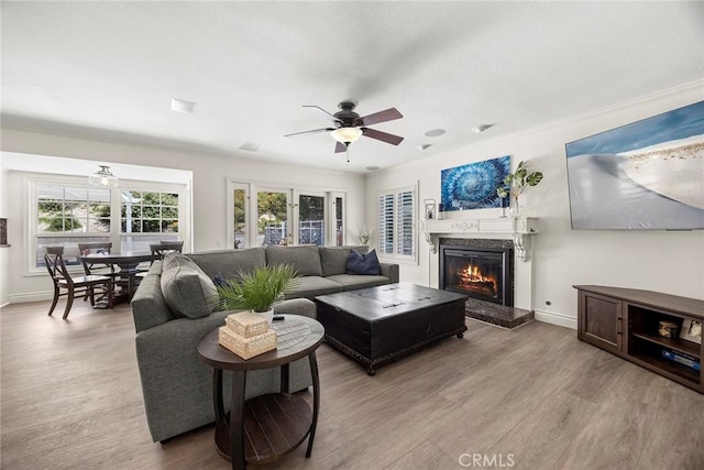 20660 Calle Feliz, Yorba Linda, CA 92886 - living area featuring wood finished floors, a warm lit fireplace, and a ceiling fan