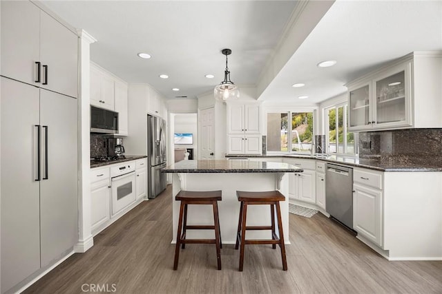 20660 Calle Feliz, Yorba Linda, CA 92886 - kitchen with stainless steel appliances, decorative backsplash, wood finished floors, a kitchen breakfast bar, and recessed lighting