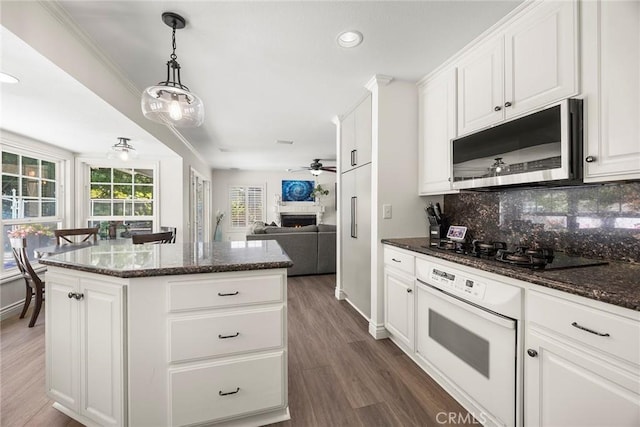 20660 Calle Feliz, Yorba Linda, CA 92886 - kitchen with stainless steel microwave, white oven, black gas stovetop, a center island, and backsplash