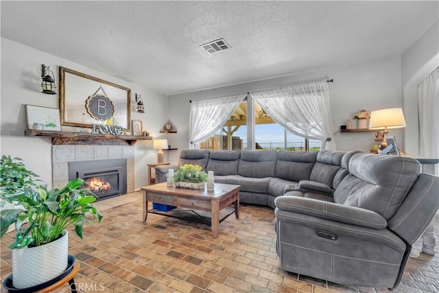 2832 Owens Way, Rosamond, CA 93560 - living area featuring a fireplace, brick patterned flooring, and a textured ceiling