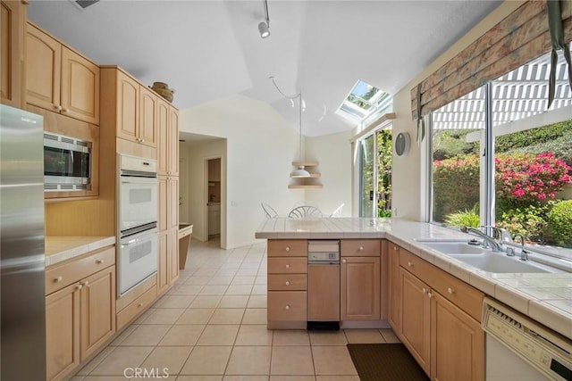 48 Siena, Laguna Niguel, CA 92677 - kitchen with appliances with stainless steel finishes, lofted ceiling, a sink, light tile patterned floors, and tile countertops