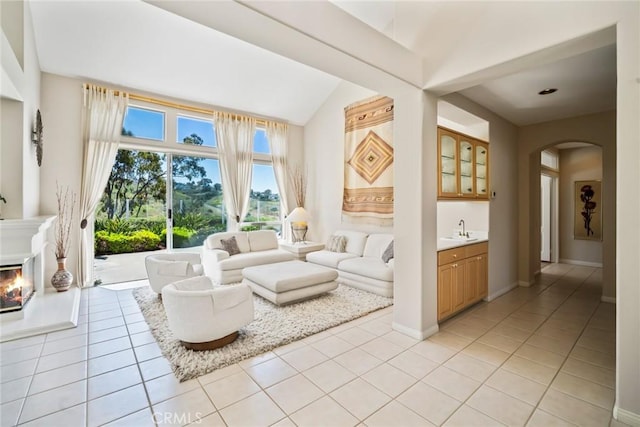 48 Siena, Laguna Niguel, CA 92677 - living room featuring arched walkways, light tile patterned floors, vaulted ceiling, and baseboards