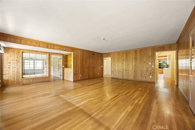 85 S San Rafael Ave, Pasadena, CA 91105 - unfurnished living room featuring wood walls, light wood-type flooring, baseboards, and ornamental molding