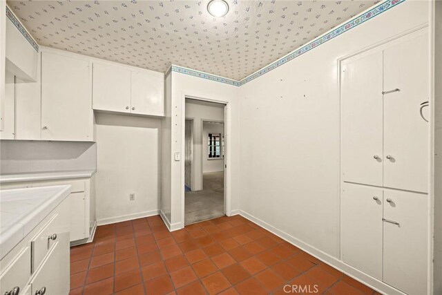 85 S San Rafael Ave, Pasadena, CA 91105 - kitchen featuring tile countertops, dark tile patterned floors, white cabinets, and baseboards