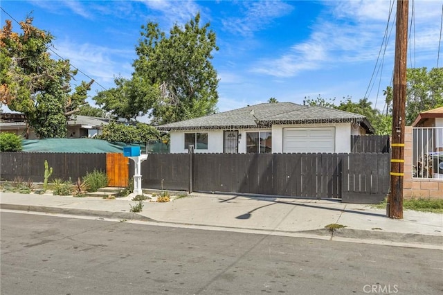 1676 W 8th St, San Bernardino, CA 92411 - view of front of property with a garage, a fenced front yard, and stucco siding