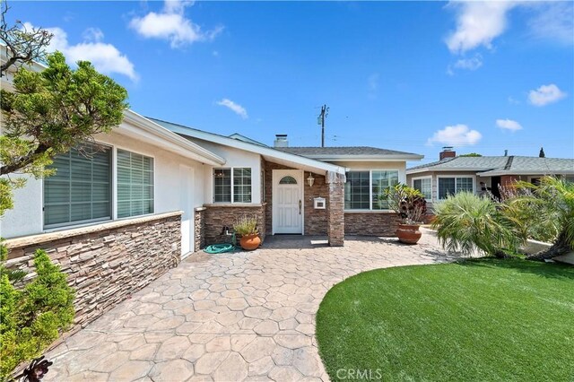 1825 Leola St, Lomita, CA 90717 - view of front of house with stone siding, a front yard, and stucco siding