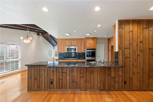 1825 Leola St, Lomita, CA 90717 - kitchen with stainless steel appliances, backsplash, brown cabinets, a peninsula, and recessed lighting