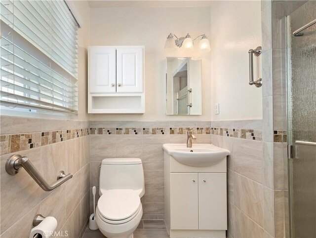 1825 Leola St, Lomita, CA 90717 - bathroom featuring a shower stall, vanity, tile walls, toilet, and wainscoting