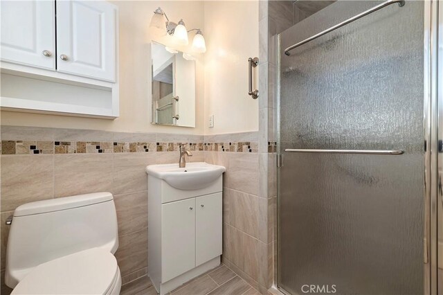 1825 Leola St, Lomita, CA 90717 - bathroom featuring tile walls, vanity, a stall shower, toilet, and a wainscoted wall