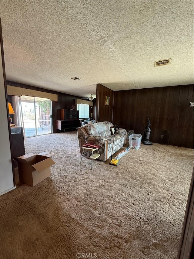 72400 El Paseo Dr Unit 29, Palms, CA 92277 - living room with carpet floors, a textured ceiling, and wooden walls