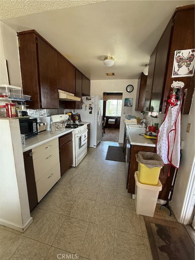72400 El Paseo Dr Unit 29, Palms, CA 92277 - kitchen with white appliances, under cabinet range hood, light countertops, and dark brown cabinets