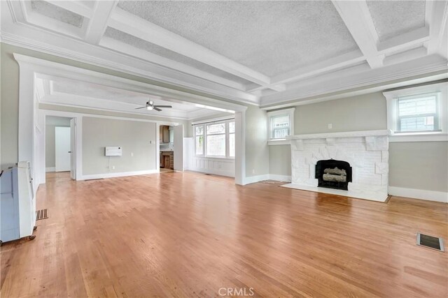 142 S Ardmore Ave, Los Angeles, CA 90004 - unfurnished living room with a stone fireplace, coffered ceiling, ornamental molding, beam ceiling, and a ceiling fan
