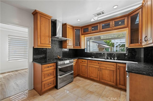 645 Glenmore Blvd, Glendale, CA 91206 - kitchen featuring double oven range, wall chimney range hood, brown cabinets, dark stone counters, and decorative backsplash