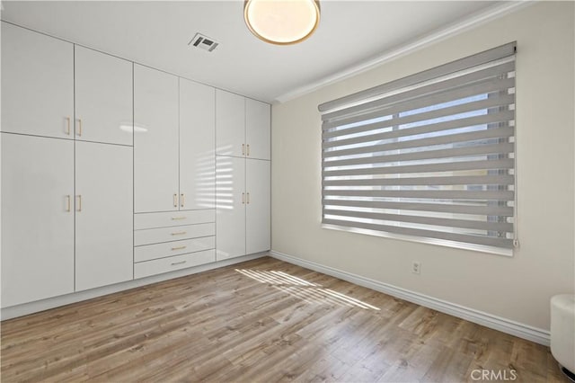 645 Glenmore Blvd, Glendale, CA 91206 - unfurnished bedroom featuring crown molding, light wood finished floors, baseboards, and a closet