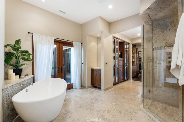 32661 Caribbean Dr, Dana Point, CA 92629 - bathroom with french doors, a shower stall, a freestanding bath, recessed lighting, and vanity