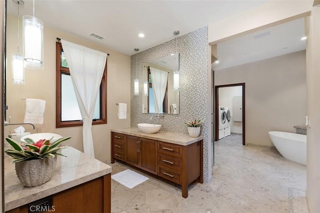 32661 Caribbean Dr, Dana Point, CA 92629 - full bathroom with washer and dryer, vanity, and a freestanding tub