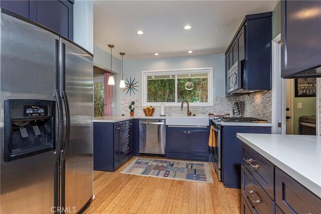 16733 Archwood St, Van Nuys, CA 91406 - kitchen with appliances with stainless steel finishes, light wood-type flooring, backsplash, blue cabinets, and light countertops