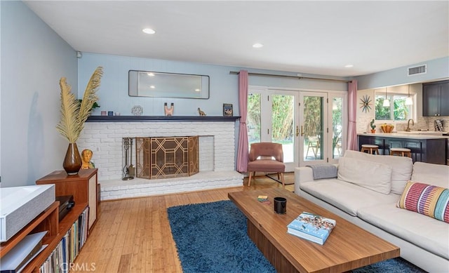 16733 Archwood St, Van Nuys, CA 91406 - living area with light wood-type flooring, french doors, a fireplace, plenty of natural light, and recessed lighting