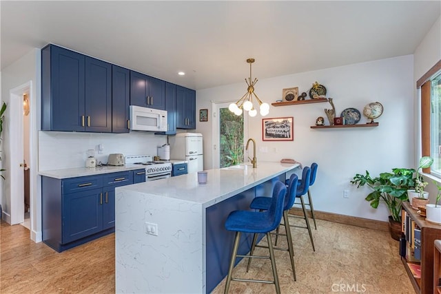 16733 Archwood St, Van Nuys, CA 91406 - kitchen featuring white appliances, blue cabinets, a kitchen bar, a peninsula, and baseboards