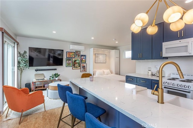 16733 Archwood St, Van Nuys, CA 91406 - kitchen featuring white appliances, blue cabinetry, an AC wall unit, open floor plan, and light stone counters