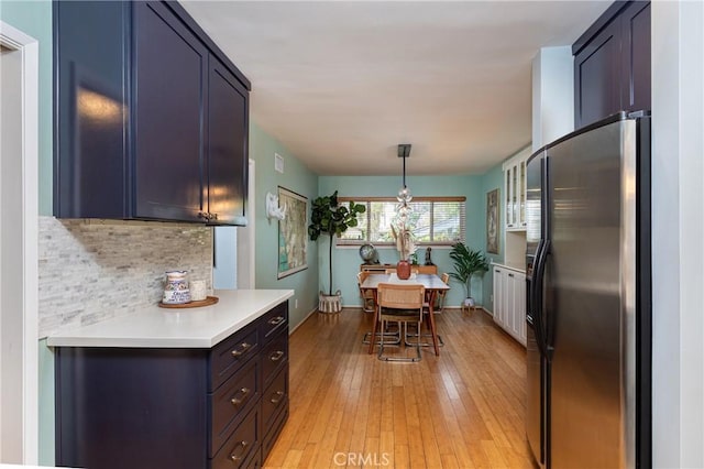 16733 Archwood St, Van Nuys, CA 91406 - kitchen with stainless steel refrigerator with ice dispenser, backsplash, light countertops, light wood-type flooring, and pendant lighting