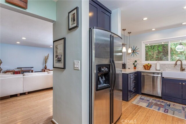 16733 Archwood St, Van Nuys, CA 91406 - kitchen featuring appliances with stainless steel finishes, a sink, light wood-type flooring, light countertops, and tasteful backsplash