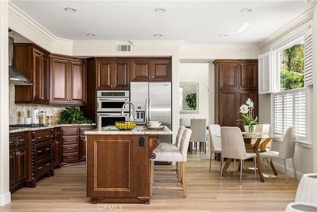 14 Celonova Pl, Lake Forest, CA 92610 - kitchen with stainless steel appliances, light wood-type flooring, crown molding, a center island with sink, and decorative backsplash