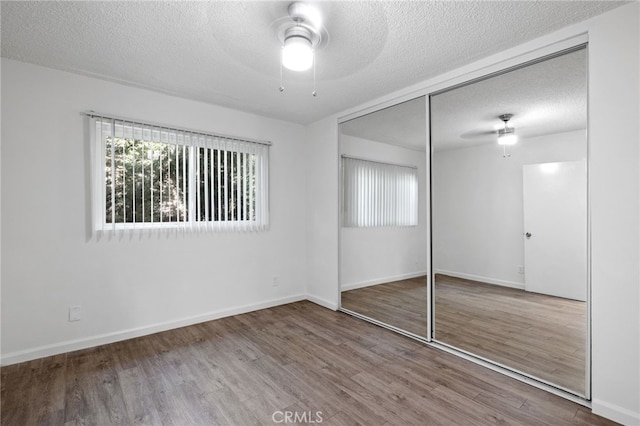 3337 S Durango Ave, Los Angeles, CA 90034 - unfurnished bedroom with wood finished floors, a closet, a textured ceiling, baseboards, and a ceiling fan