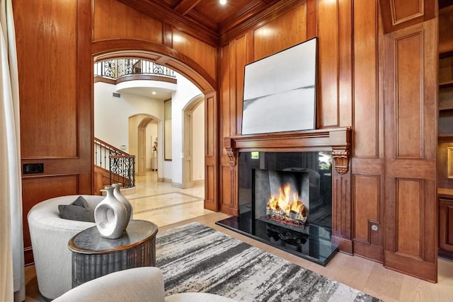 5106 Meadows Del Mar, San Diego, CA 92130 - living area with arched walkways, a premium fireplace, stairs, light wood finished floors, and wooden walls