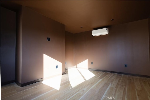 3977 Sage Ave, Yucca Valley, CA 92284 - empty room with light wood finished floors, a wall mounted air conditioner, baseboards, and recessed lighting
