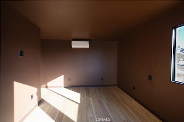 3977 Sage Ave, Yucca Valley, CA 92284 - additional living space featuring a wall mounted air conditioner, light wood-style flooring, baseboards, and plenty of natural light